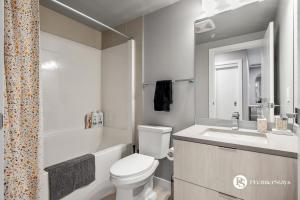 a white bathroom with a toilet and a sink at Central Downtown near Rogers Sleeps 6 with Two Queen Beds and Parking in Edmonton +36 photos