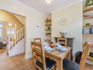 a dining room with a table and chairs and a clock at 2 Bed in Eastbourne EHC06 in Eastbourne