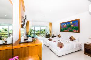 a hotel room with two beds and a desk at Lamai Coconut Beach Resort in Lamai