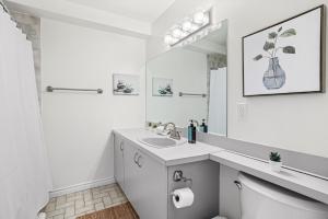 a white bathroom with a sink and a mirror at Stunning One-Bedroom Condo With Lake View in Mont-Tremblant +11 photos
