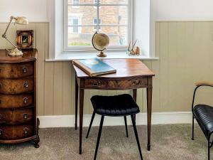 Saint Margarets HopeにあるThe Legionの本と椅子と窓のある机