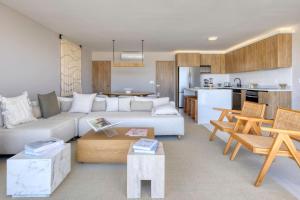 a living room with a white couch and a kitchen at New and Elegant 4Bedroom House Steps from the Beach in Cabo San Lucas