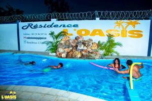 a group of people in a swimming pool at a resort at Résidence LOASIS in Mahajanga