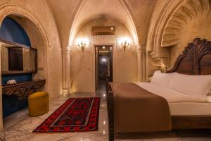 ein Schlafzimmer mit einem Bett, einem Tisch und einem Spiegel in der Unterkunft Signature Cave Cappadocia, Trademark Collection by Wyndham in Ürgüp + 291 Fotos