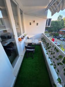 a balcony with a table and chairs and green grass at Apartman BELLA in Doboj