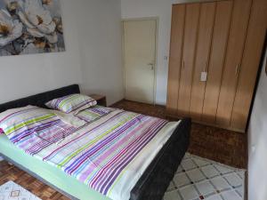 a bedroom with a bed with a striped blanket at Apartman BELLA in Doboj