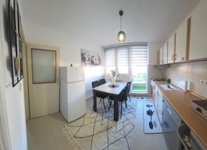 a small kitchen with a table and a refrigerator at Apartman BELLA in Doboj +2 photos
