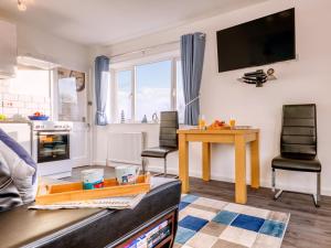 Una sala de estar con televisión, mesa y sillas. en 1 bed in Filey 77709, en Hunmanby