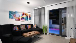 a living room with a black couch and a table at Villa de la Luna in Los Alcázares +60 photos