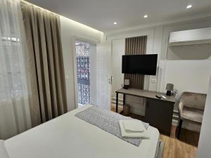 a hotel room with a bed and a desk and a television at TRE'S BLISS City Heart Villa!!! in Durrës