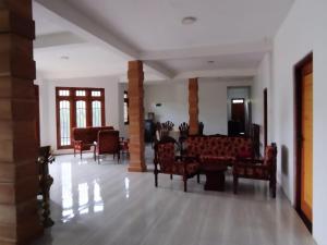 ein Wohnzimmer mit Stühlen und Tischen in einem Gebäude in der Unterkunft Ceylon Elegant in Ella