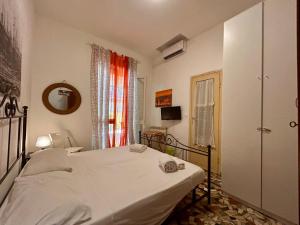 Un dormitorio con una cama blanca y una ventana. en Apartments Viareggio, en Viareggio