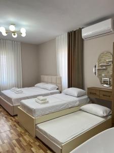 a bedroom with three beds and a mirror at Asper Vila in Pogradec
