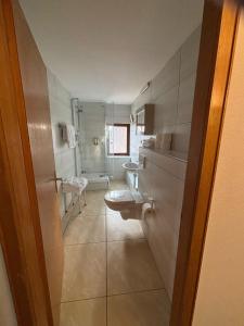 a bathroom with two sinks and a toilet at Parkhotel Goldlinde in Bodenwerder