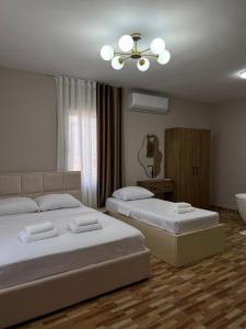 a bedroom with two beds and a ceiling fan at Asper Vila in Pogradec