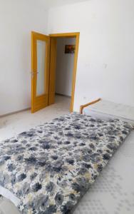 a bedroom with a bed with a blue and white comforter at Guest House 369 in Jajce