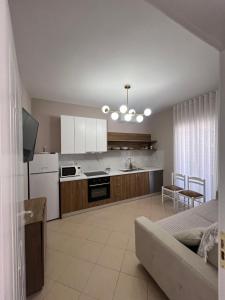 a kitchen with white cabinets and a living room at Asper Vila in Pogradec +14 photos