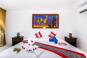 a bedroom with a bed with a red and white blanket at Lamai Coconut Beach Resort in Lamai
