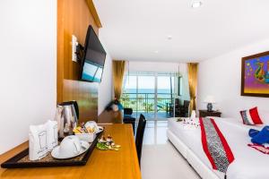 a hotel room with a bed and a dining table at Lamai Coconut Beach Resort in Lamai