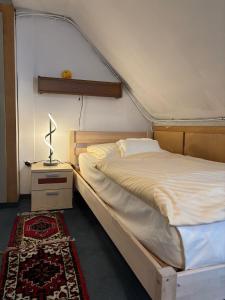 a bedroom with a bed and a lamp on a table at Parkhotel Goldlinde in Bodenwerder