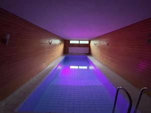 a swimming pool with purple lights in a building at Large apartment in the centre of Jyväskylä with private swimming pool and sauna in Jyväskylä +11 photos