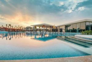 ein großes Schwimmbad vor einem Gebäude in der Unterkunft Swan lake magical chalet! North coast in Zāwiyat al ‘Awwāmah + 14 Fotos