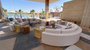 ein großes Wohnzimmer mit Sofas und einem Pool in der Unterkunft Swan lake magical chalet! North coast in Zāwiyat al ‘Awwāmah