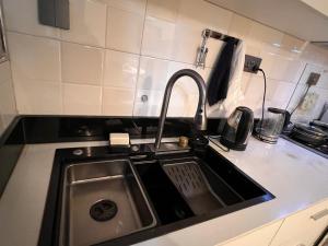 a kitchen sink with a faucet in a kitchen at Home2Suite by Veronica Bunga-Buziga-Munyonyo- Luxury with Netflix, DStv, Wi-Fi, & Free Parking in Kampala