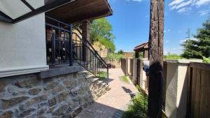 a porch of a house with a stone wall at Casa de pe stâncă in Sibiel