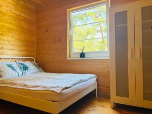 a bedroom with a bed and a window at Błękitna Przystań Pobierowo in Pobierowo