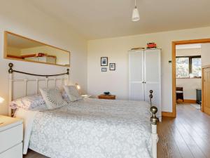 una camera da letto con un letto bianco e uno specchio di 4 bed in Glastonbury SHALO a Greinton