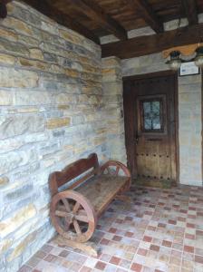 a wooden bench sitting in the corner of a stone wall at Sagardikoetxea HABITACIONES CON BAÑO EN CASA RURAL in Oskotz