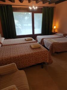 a hotel room with three beds and a window at Sagardikoetxea HABITACIONES CON BAÑO EN CASA RURAL in Oskotz +9 photos