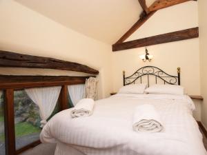 a bedroom with a bed with white sheets and a window at 3 Bed in Hope PK432 in Aston