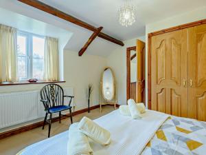a bedroom with a bed and a chair and a mirror at 3 Bed in Builth Wells 52463 in Alltmawr +21 photos