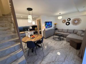una sala de estar con una mesa y un sofá en Hellenikon Suites Malama, en Paralia Katerinis