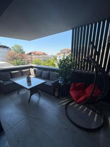 Una sala de estar con un sofá y una mesa en un balcón. en Hellenikon Suites Malama, en Paralia Katerinis