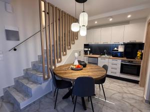 Una cocina y un comedor con mesa y sillas. en Hellenikon Suites Malama, en Paralia Katerinis