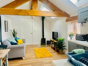 - un salon avec un canapé et une cuisinière dans l'établissement 200 yr old Barn Conversion ,Near Carlisle, the Borders and the North Pennines in peaceful village location, à Castle Carrock