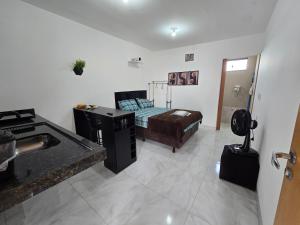 a room with a bed and a desk in it at Flat completo 18 minutos da Pecuária de Aparecida de Goiania in Aparecida de Goiania