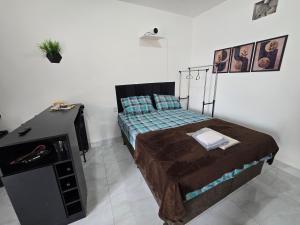 a bedroom with a bed and a dresser in it at Flat completo 18 minutos da Pecuária de Aparecida de Goiania in Aparecida de Goiania