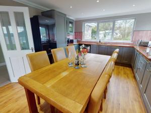 a kitchen with a wooden table with chairs and a counter at 3 bed property in Onich CA159 in Onich