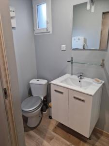 une salle de bains blanche avec toilettes et lavabo dans l'établissement La Cabane du bois l'abbé, à Saint-Martin-Boulogne