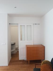 a room with a white door and a wooden cabinet at Dacoté Duplex in La Croix-Helléan
