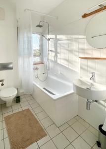 a bathroom with a tub and a toilet and a sink at Cosy Green - Exklusiv LIVING in Hochheim in Hochheim am Main
