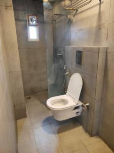 a bathroom with a white toilet in a stall at SwagStay Hotel Century, Nagpur in Nagpur