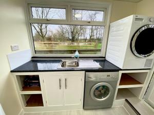 a kitchen with a washing machine and a window at 1 Bed in New Quay 77496 in Lampeter
