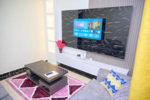 a living room with a tv on a wall at SpringStone executive apartment A10 in Ongata Rongai 