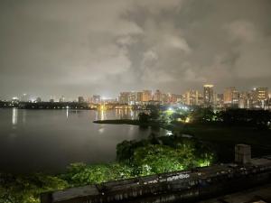a city skyline at night with a large body of water at Lake View 2 BHK in Powai A in Mumbai