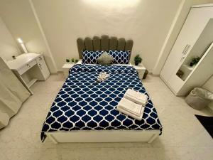 a bedroom with a blue and white bed and a sink at Lake View 2 BHK in Powai A in Mumbai